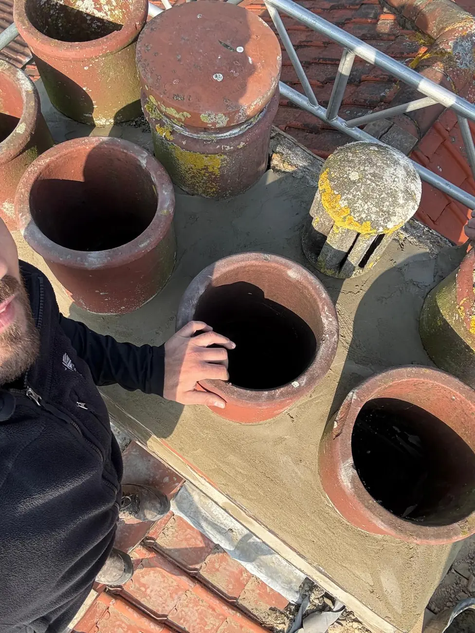 Fresh mortar flaunching finished around reset chimney pots in Ipswich