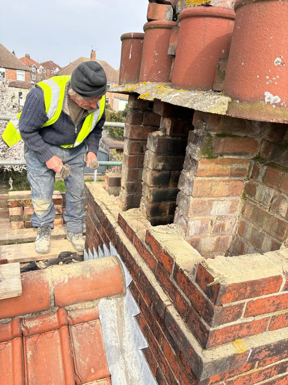 Stormproof roofer in hi-vis rebuilding a chimney stack on Lancaster Road, Ipswich