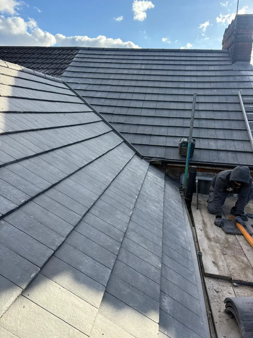 Completed grey tiled roof with reformed hips and valleys on a re-roof in Diss