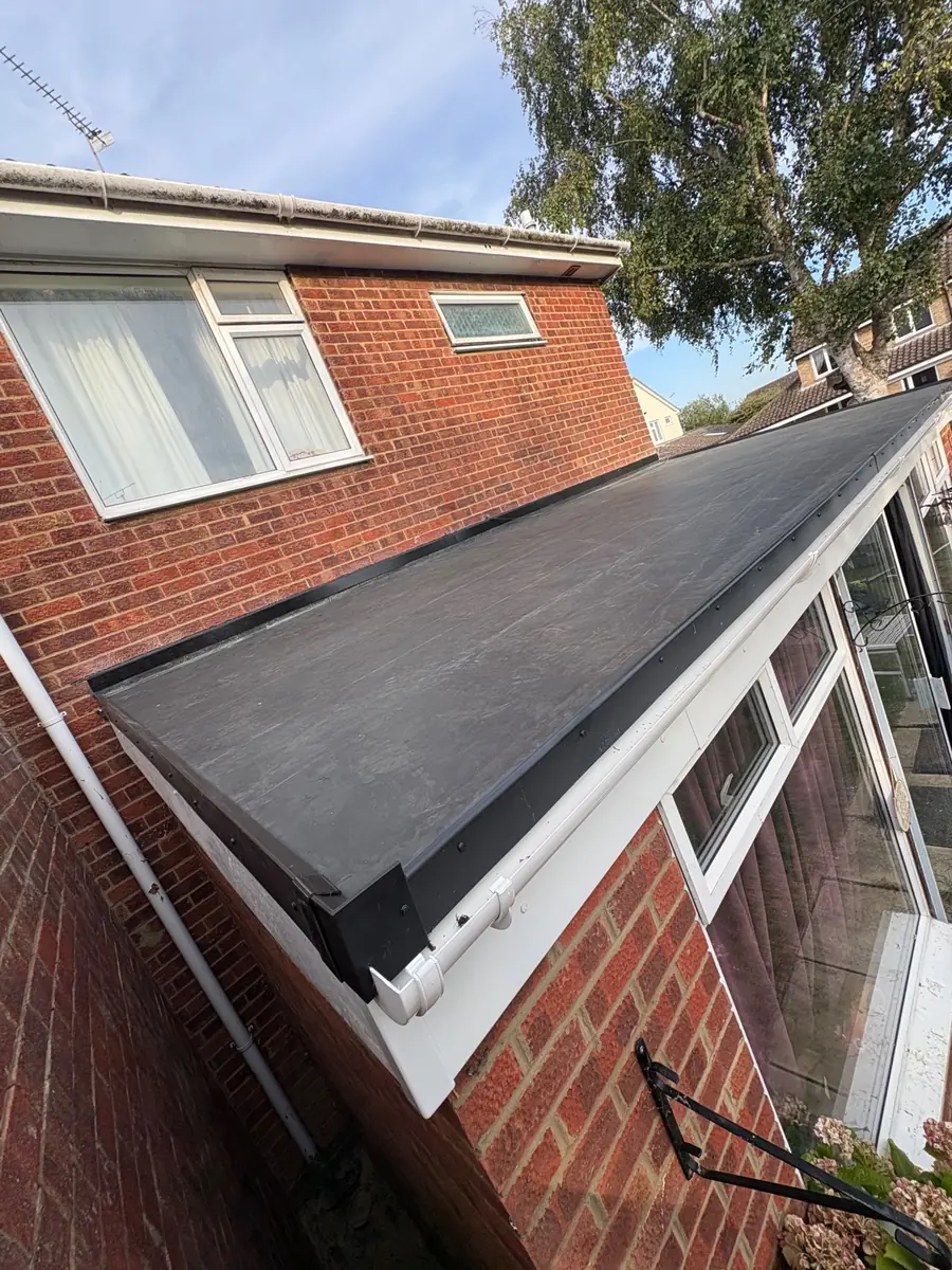 The same rear extension flat roof from the other end, showing the membrane dressed over the edge trim