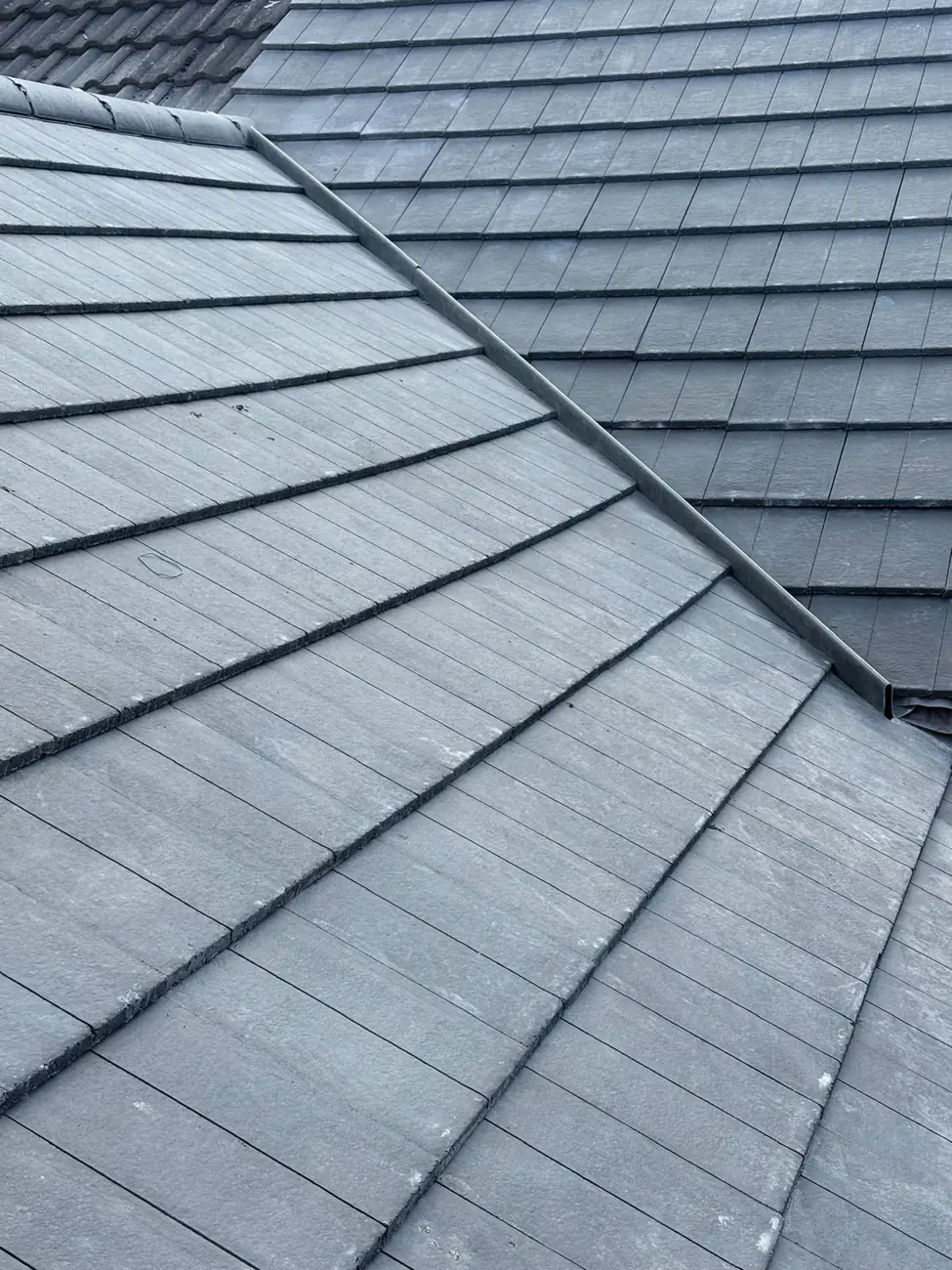 Hip detail on a newly laid grey interlocking tiled roof in Diss
