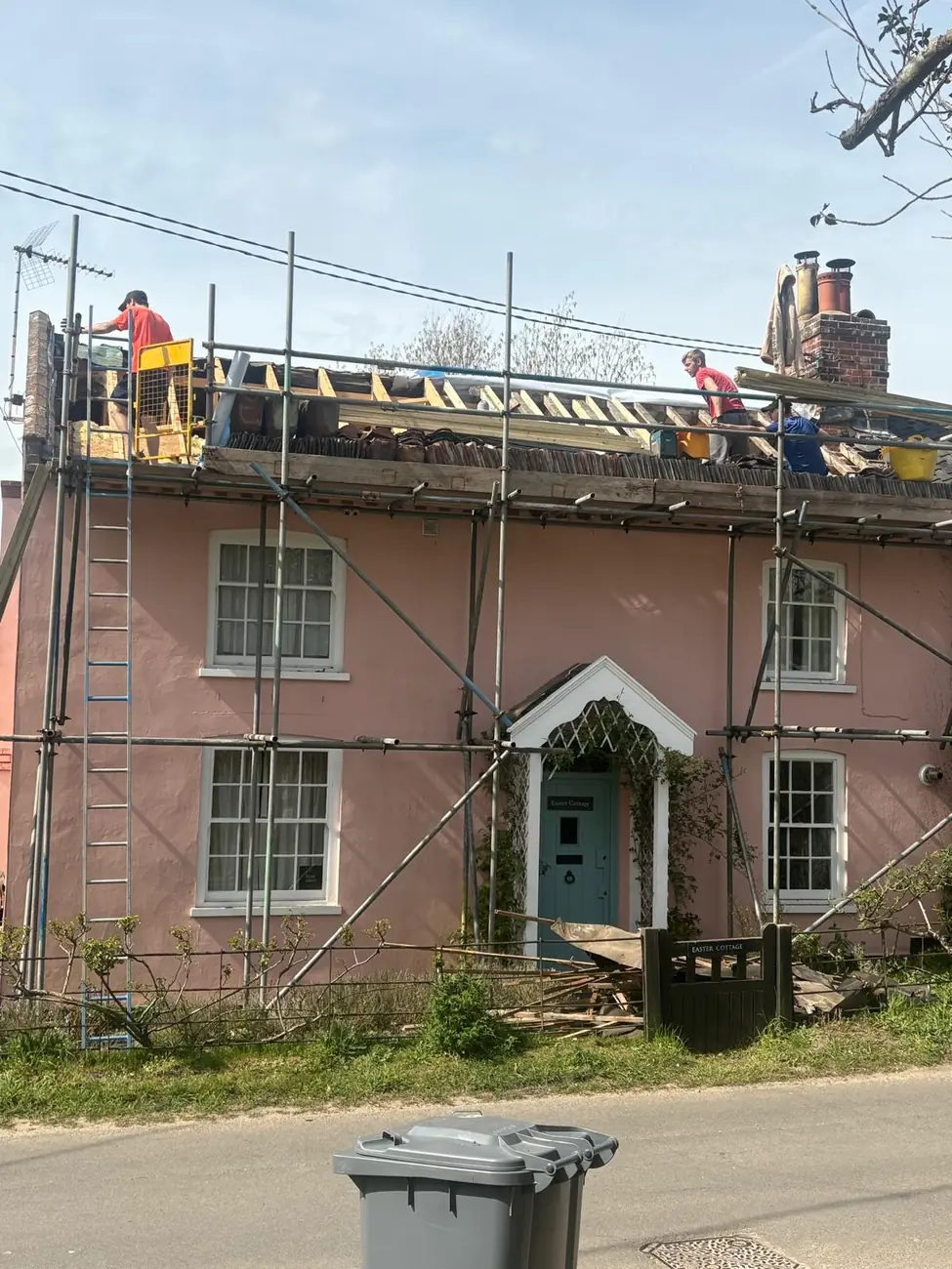 Rendered Suffolk period cottage under scaffold with Stormproof roofers working on the roof