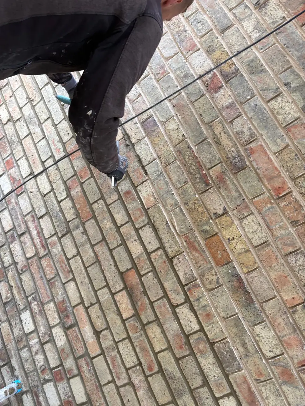 Failed mortar joints being ground out before repointing in Woodbridge