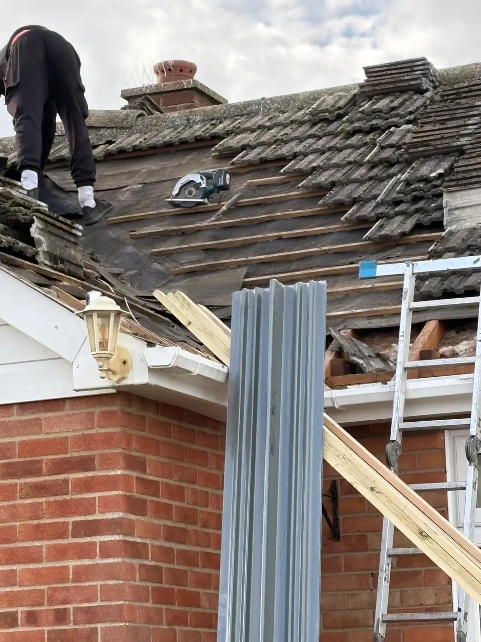 Stormproof roofer stripping the old covering from a terraced roof in Ipswich